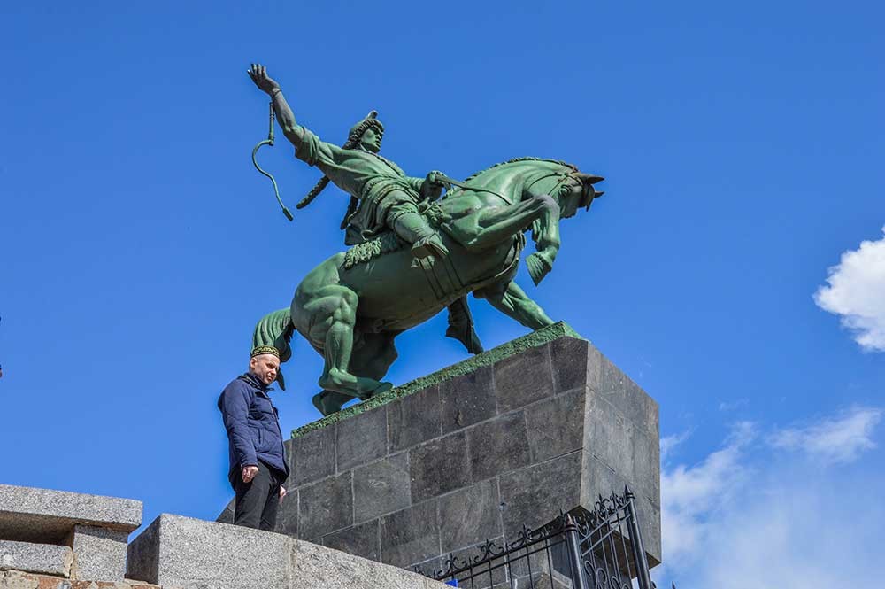 Patung Salavat Yulayev dan seorang pria yang memakai topi khas Bashkir.