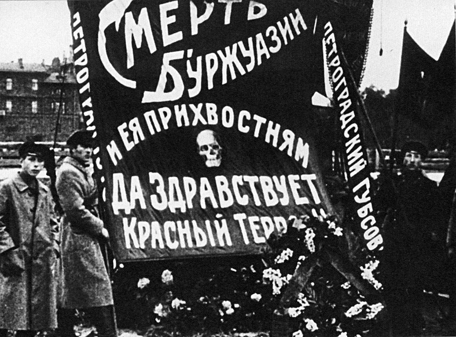 モイセイ・ウリツキーの墓のそばにいる管理人たち。ペトログラード。ポスターには「ブルジョワおよびその支援者を殺せ！赤色テロ、万歳！」と書いてある。