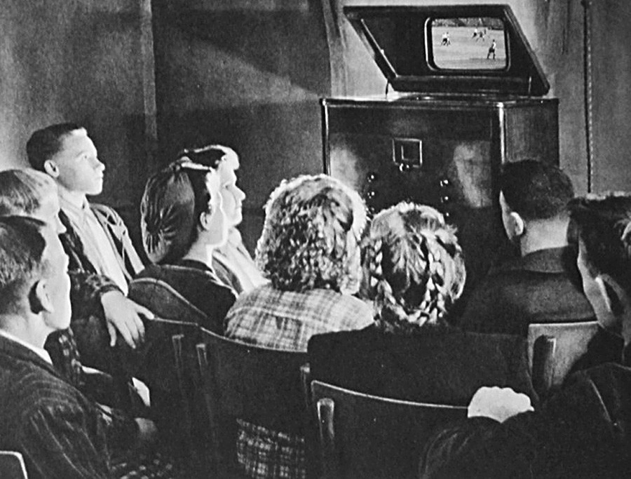 モスクワ州のコルホーズ（集団農場）でサッカーファンがモスクワのディナモ・スタジウムで行われている試合の応援をしている。テレビは1939年に生産された、画面が14Х18 センチの「ТК-1」。