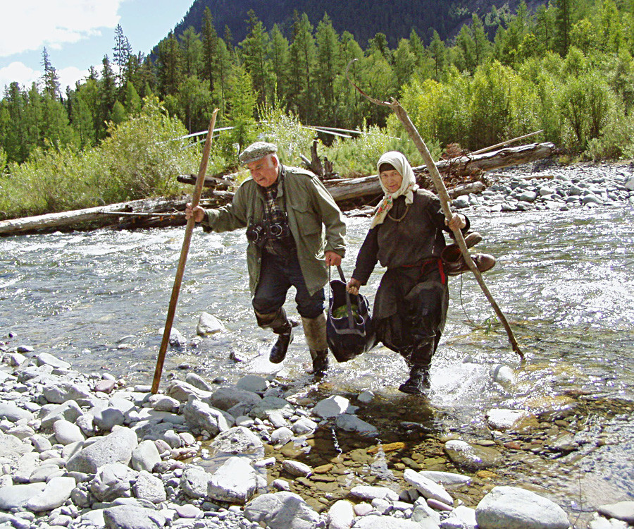 Красноярский край, Россия, 27 августа 2004 г. Отшельница Агафья Лыкова и журналист Василий Песков идут через реку Еринат. 