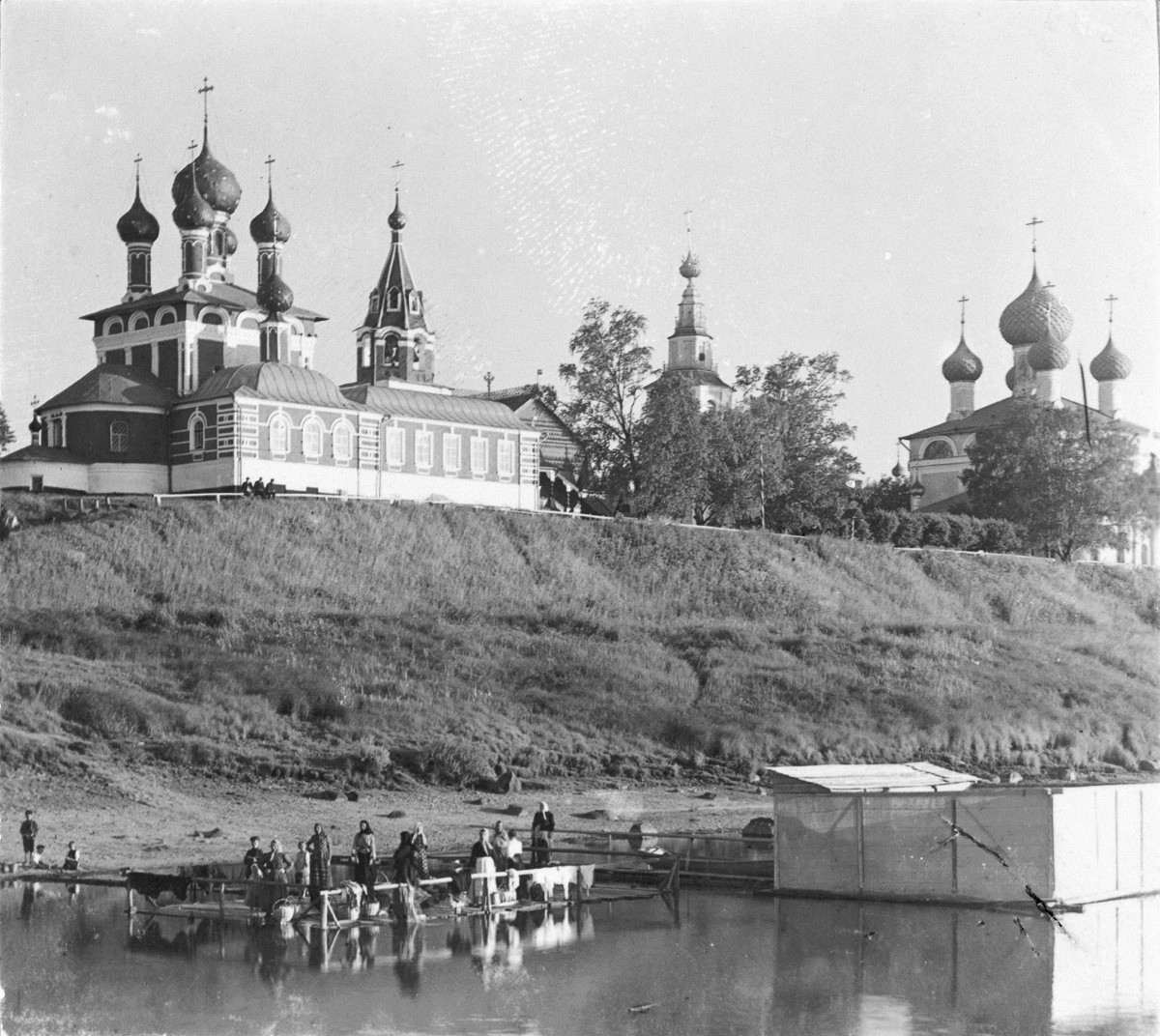 Chiesa dello Zarevic Dmitrij. Vista nord-est dal fiume Volga. Primo piano: donne che lavano i panni nel fiume Volga. A destra: Cattedrale della Trasfigurazione. Fine estate 1910