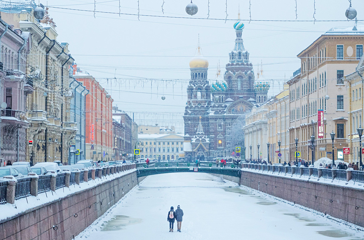 A couple walking the frozen Griboyedov Canal towards the Church of the Savior on Blood.