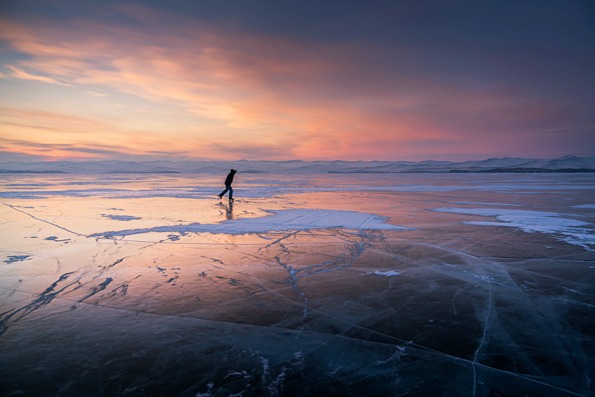 Ice of Baikal Lake, Russian nature. Skating trek.