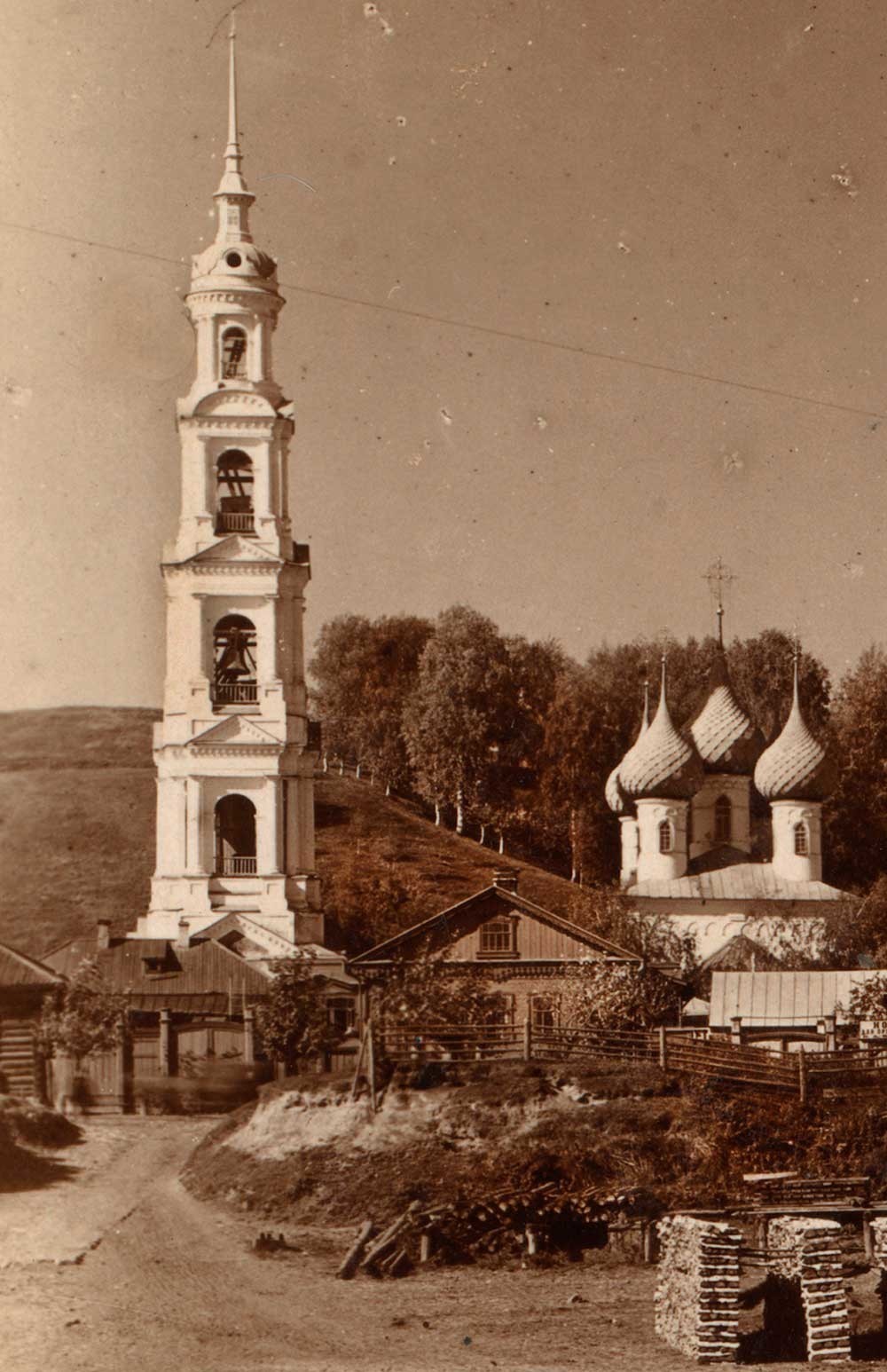 Zvonik sv. Jurija in Katedrala Kristusovega prihoda v Jeruzalem z vzhoda z reke Volge, spredaj pa zložena drva, poletje 1910.