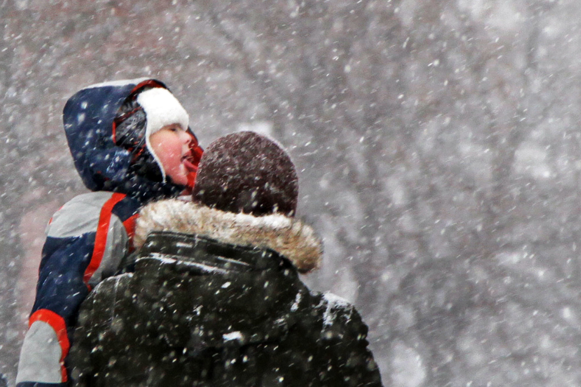 Salju lebat yang turun menarik perhatian seorang anak yang digendong sang ayah, dan ia pun menjulurkan lidah untuk menjilat salju tersebut di  Lapangan Merah, Moskow, Rusia, Sabtu (26/1). Russia Beyond/Panca Syurkani