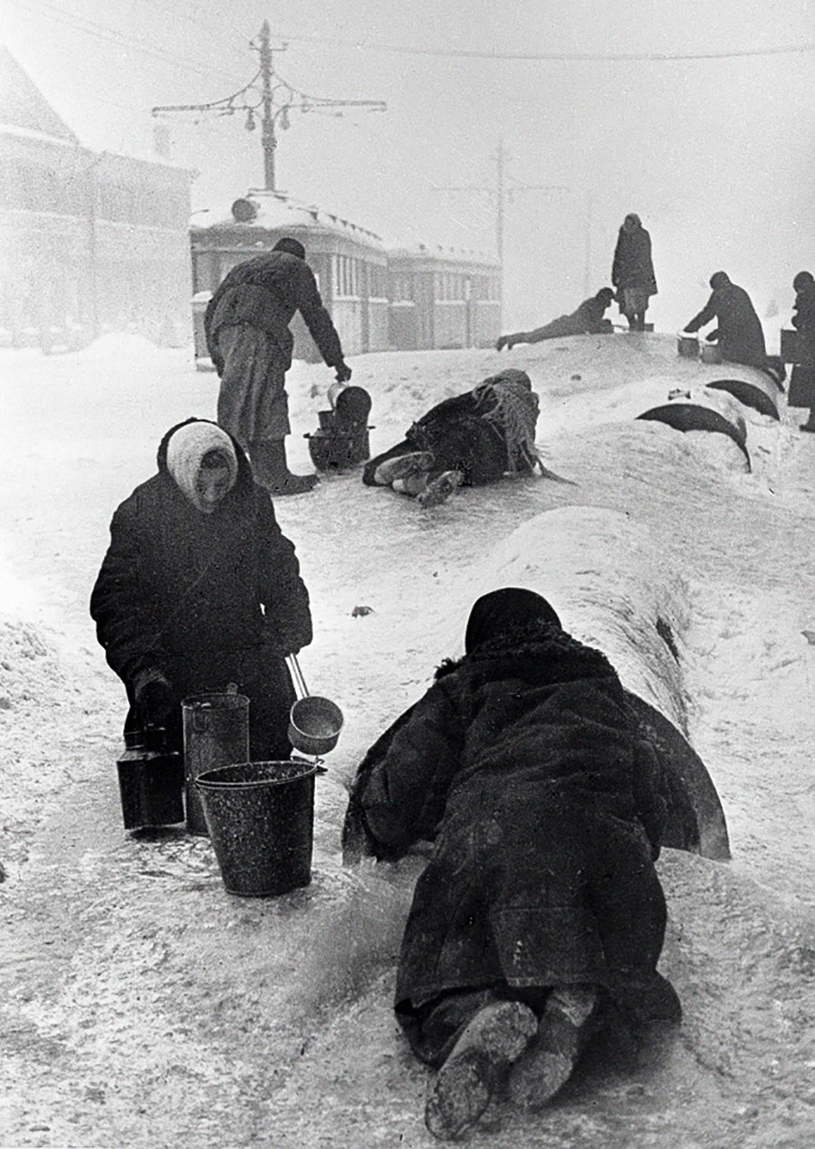 氷った通りでレニングラードの住民たちが壊れた水道から水を取っている。