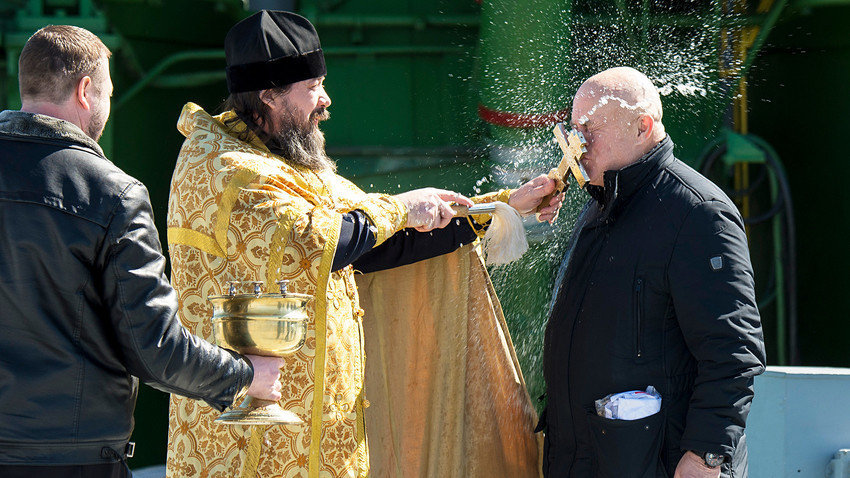 Sacerdote Ortodoxo abençoa o militar Serguêi Semtchenko, depois de ter abençoado o foguete Soiuz em lançamento do cosmódromo de Baikonur.