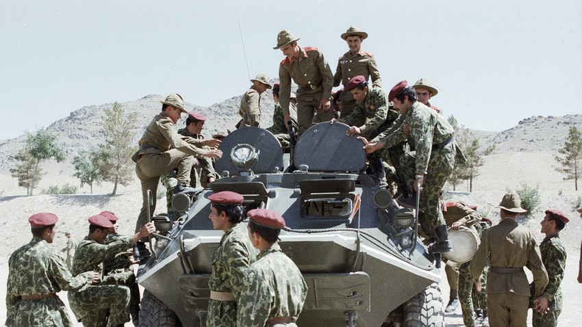 Совјетски војници показују авганистанским падобранцима војну технику.