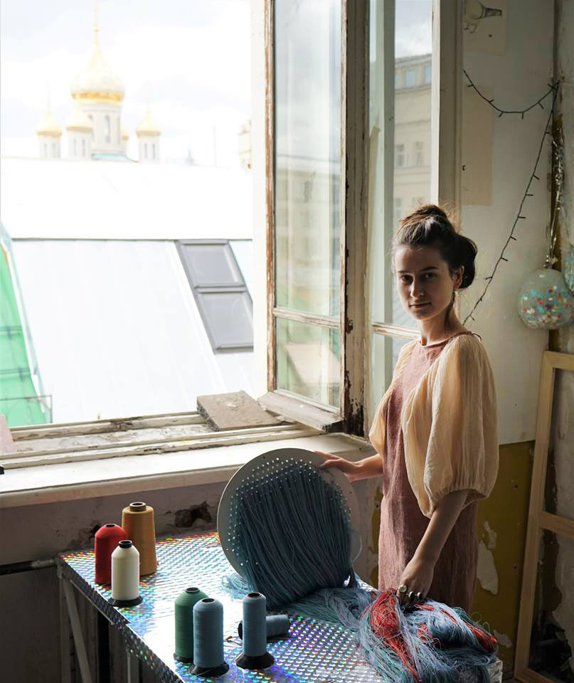Here is young artist Ustina Yakovleva standing in her downtown Moscow workshop. 