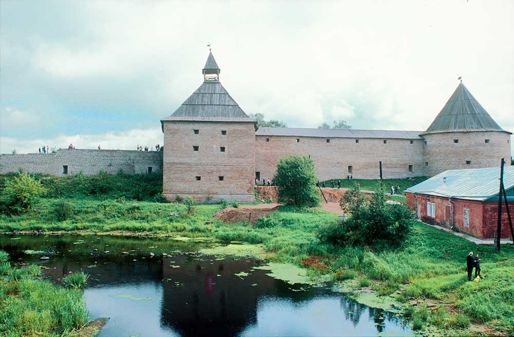 Fortezza di Staraja Ladoga. Muro ovest con la torre Vorotnaja (a sinistra) e la torre Clement. Primo piano: fiume Ladozhka. 16 agosto 2003