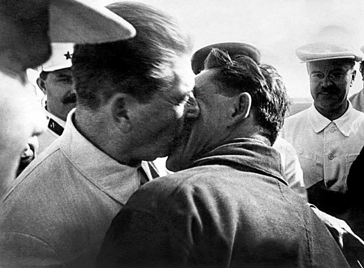 1937年4月7日。ヨシフ・スターリンがオットー・シュミットとモスクワに戻った極地パイロットヴァシリー・モロコフをキスしている。ヴァシリー・モロコフは漂流極地観測所