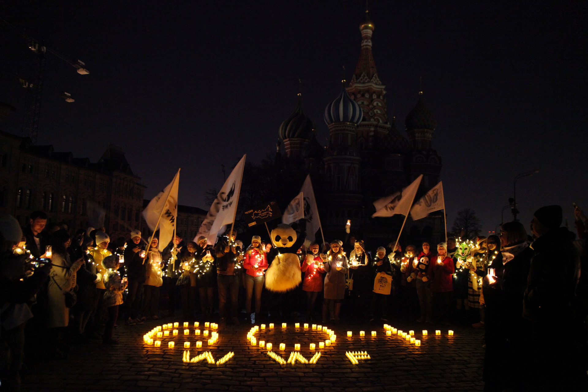 Aktivis dan masyarakat melakukan aksi Earth Hour di depan Katedral Saint Basil saat berlangsung pemadaman lampu.