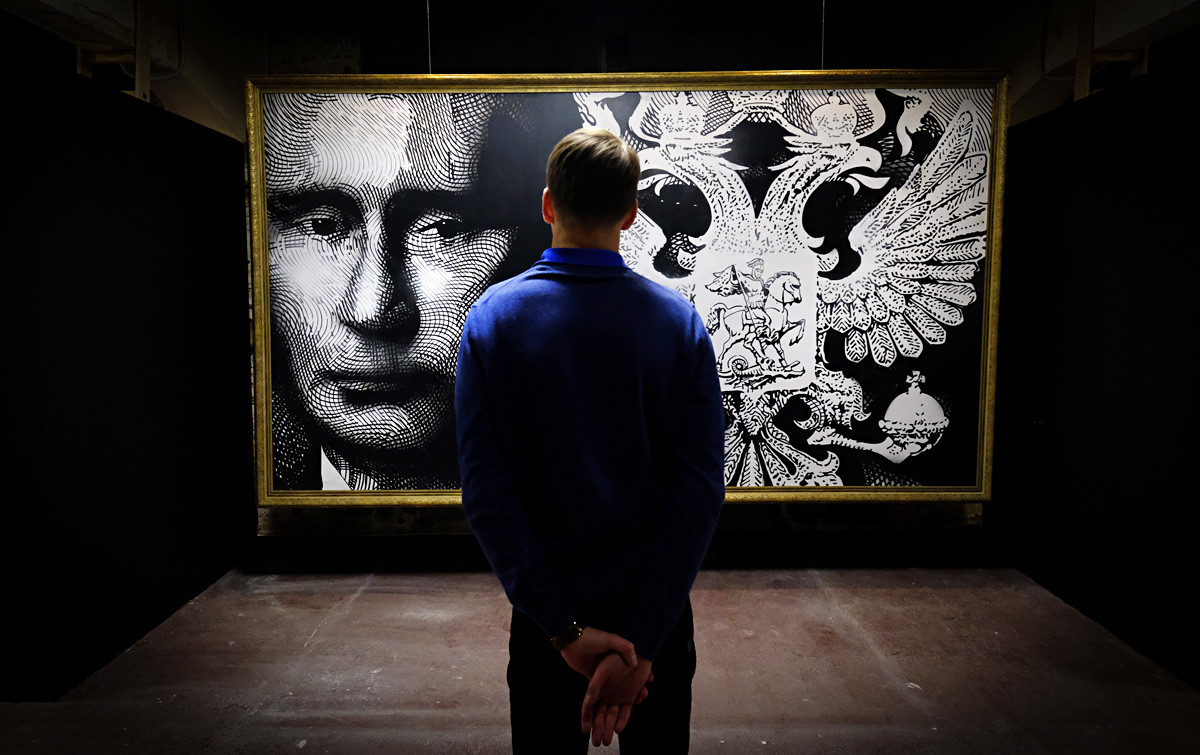 Čovjek promatra sliku koja prikazuje ruskog predsjednika Vladimira Putina na izložbi 