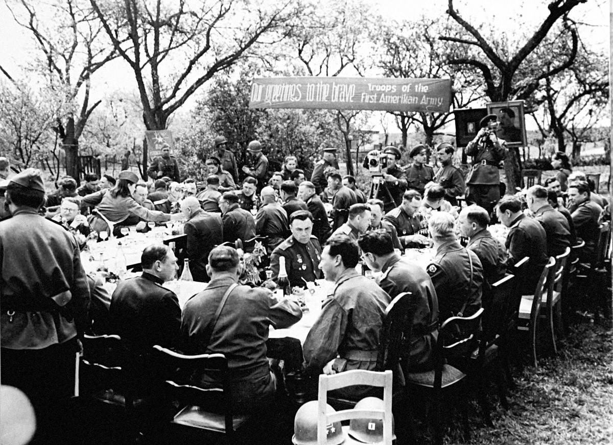 Ручак на отвореном 27. априла 1945. године у част команданата америчких и совјетских трупа које су се састале на реци Елби (Торгау, Немачка) 25. априла 1945. године. У позадини фотографија лидера Русије Јосифа Стаљина и председника САД Ф. Д. Рузвелта.