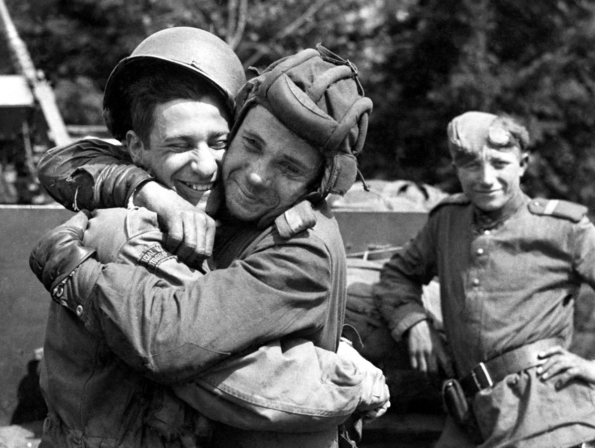 На овом снимку, који је ставила на располагање армија САД, руски војник (десно) грли фотографа 82. падобранске дивизије САД која је била придодата Другој британској армији, мај 1945. године, Грабов, Немачка.