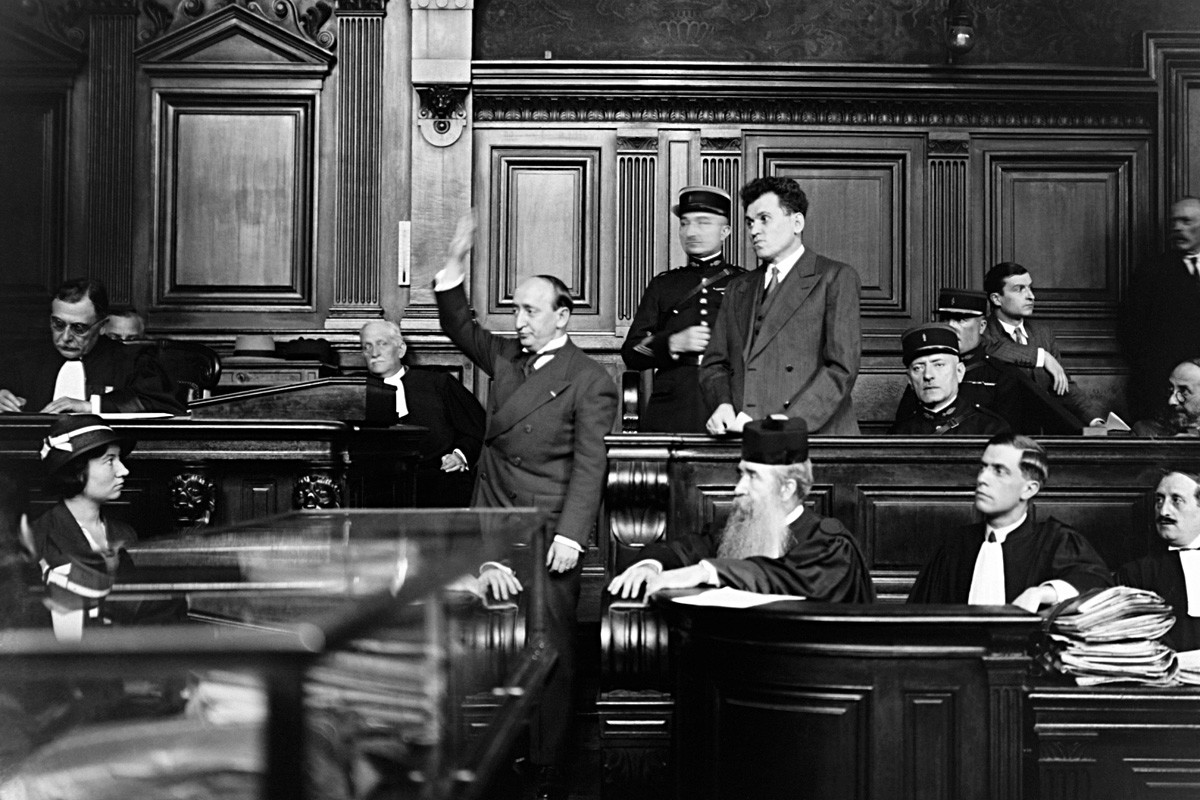 Париз, Француска, 25. јул 1932. Павел Горгулов, убица француског председника Пола Думера на оптуженичкој клупи са својим адвокатом и сведоком који полаже заклетву пре давања изјаве.