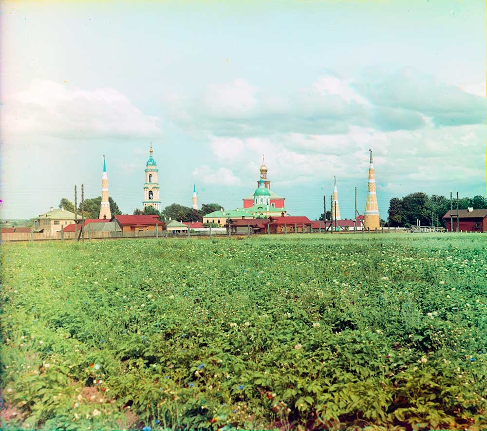 Old Golutvin Epiphany Monastery, west view. From left: northwest corner tower, bell tower, NE corner tower, Epiphany Cathedral & St. Sergius Church, SE corner tower, SW corner tower. Foreground: railroad & potato field. Summer 1912.