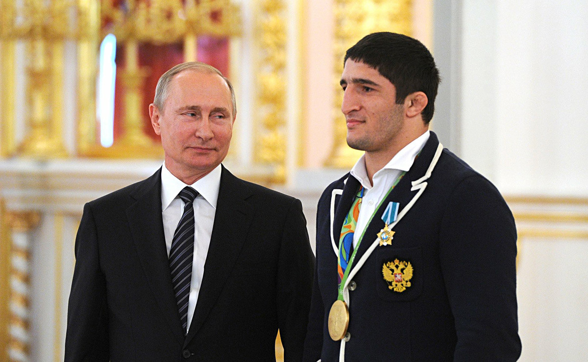 Presiden Rusia Vladimir Putin (kiri) dan juara gulat gaya bebas Olimpiade Rio 2016 Abdulrashid Sadulaev pada upacara upacara penyerahan penghargaan negara untuk Abdulrashid.