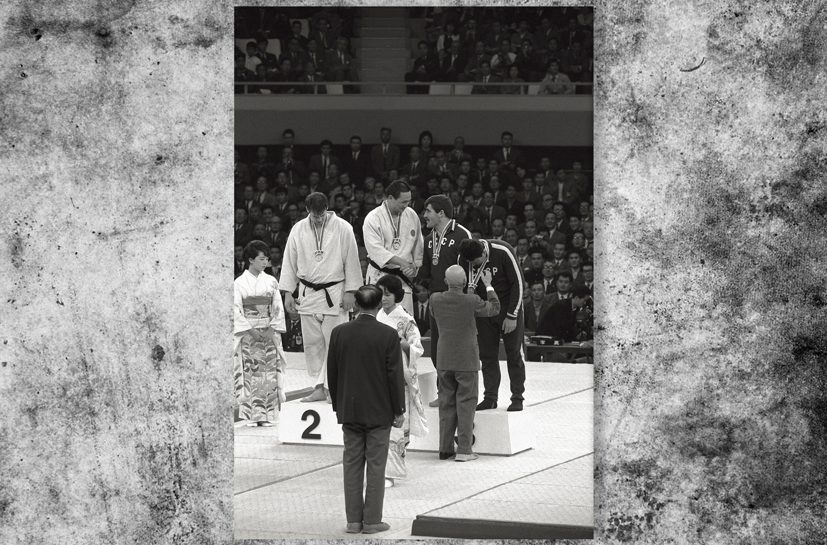 日本の柔道家、猪熊功が最重量級のメダルを受け取る。そばにはカナダのダグ・ロジャース選手、ソ連のパルナオズ・チクヴィラゼ選手とアンゾル・キクナゼ選手が立っている。東京オリンピック、1964年。