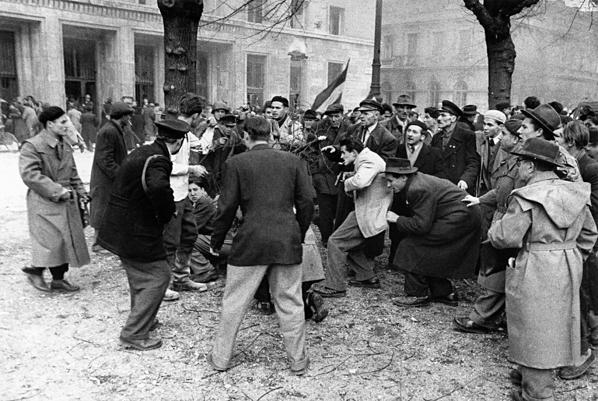 Ein Angehöriger der ungarischen Geheimpolizei (AVH) ist während des Aufstands in Budapest im November 1956 von der aufgebrachten Menge umgeben.
