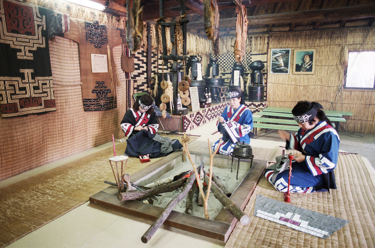 Membros dos ainus em casa em Hokkaido.