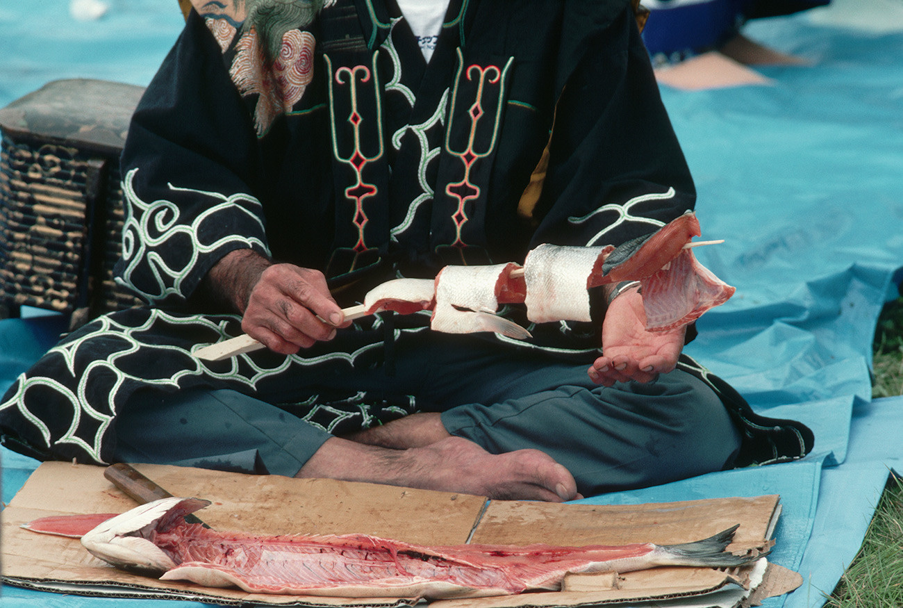 Predstavnik naroda Ainu priprema lososa na Prvom festivalu lososa.

