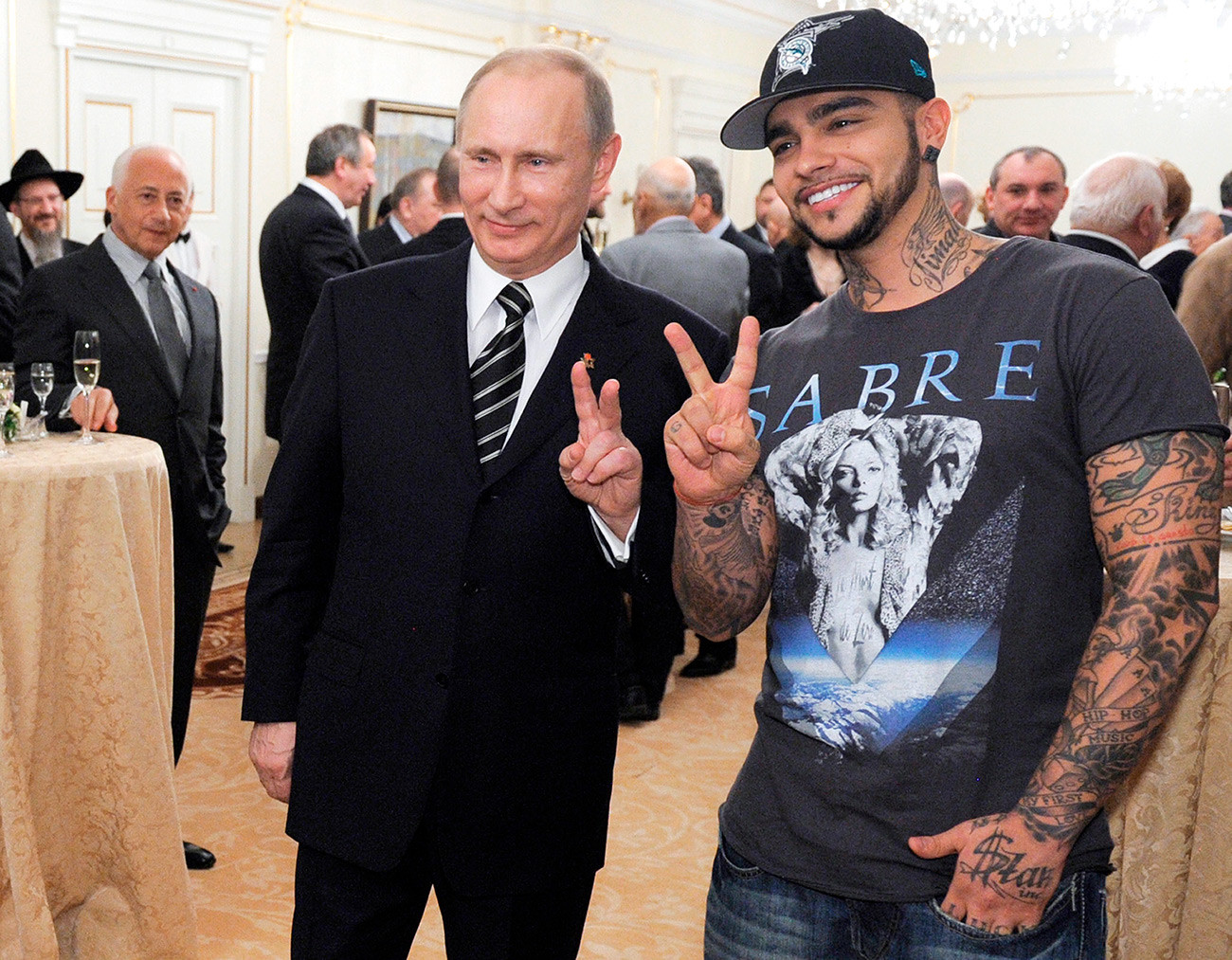 Vladimir Putin poses for a photo with rapper Timati during a meeting with his presidential elections campaign activists in Moscow