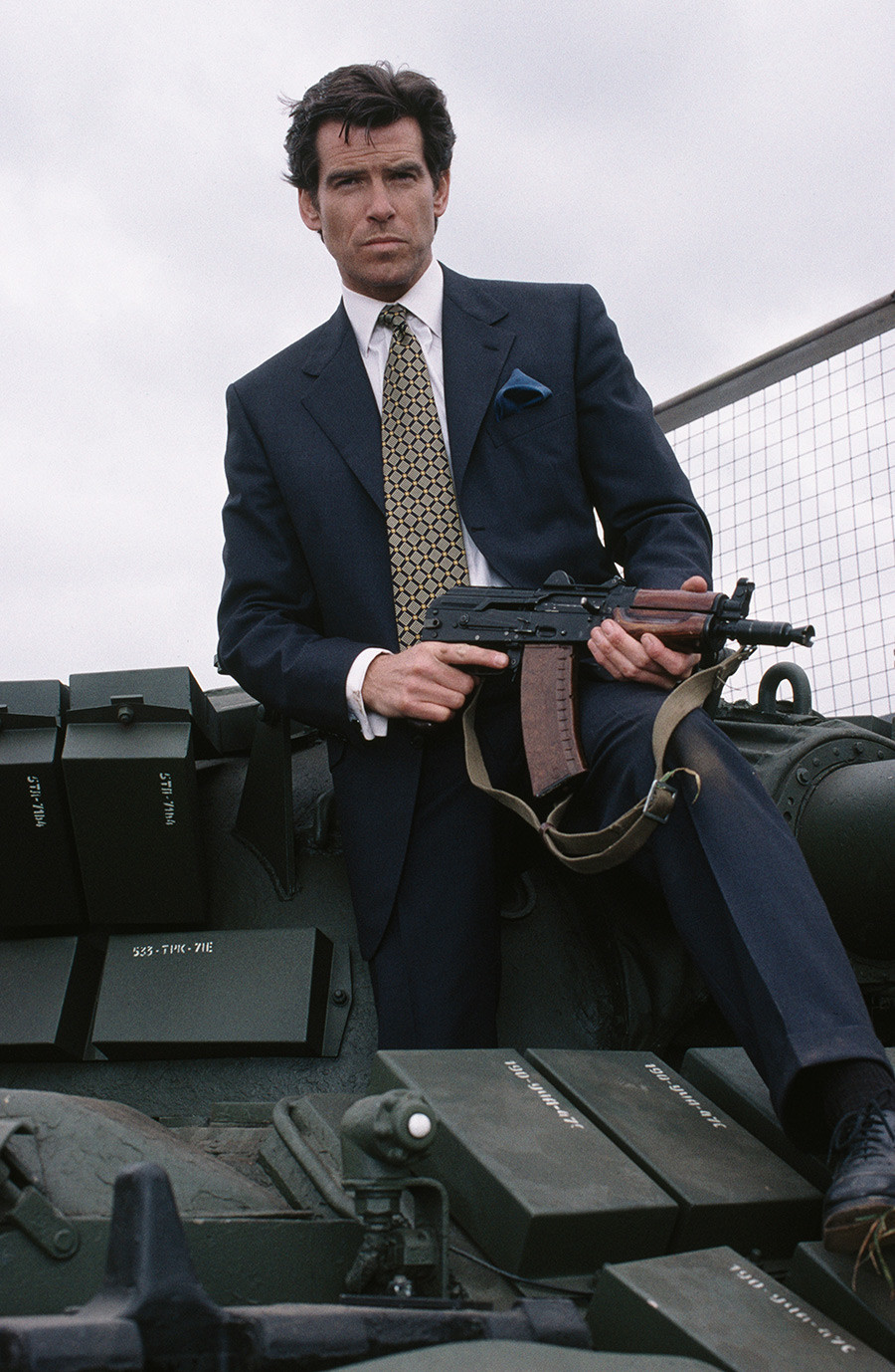 Pemeran James Bond, Pierce Brosnan, berpose dengan senapan AK dalam film ‘GoldenEye’ (1995).