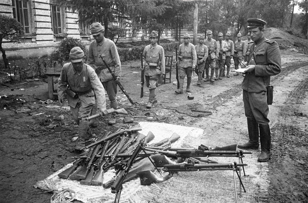Japanese soldiers lay down arms.