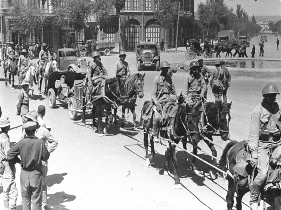 Коњи влечат артилериско оружје по улиците на ирански град.