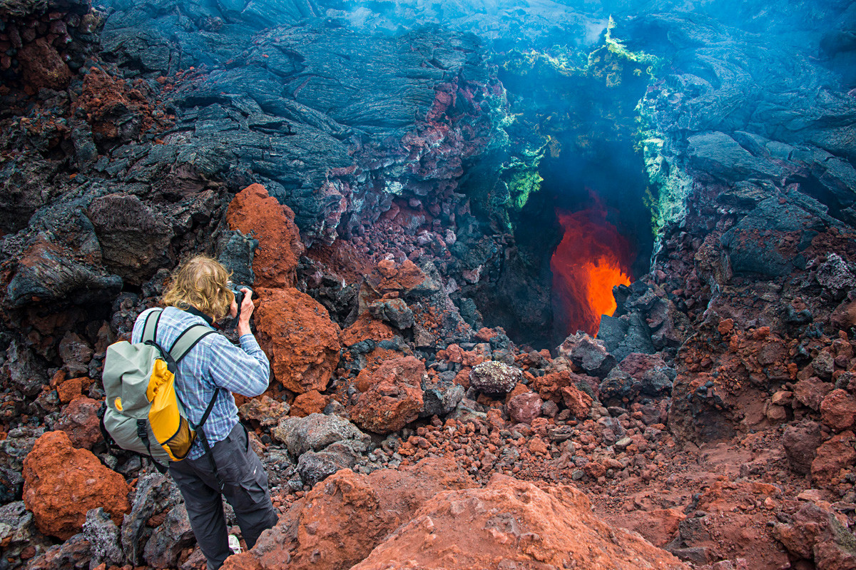 Turist fotografira aktivni potok lave pod vulkanom Tolbačik na Kamčatki.

