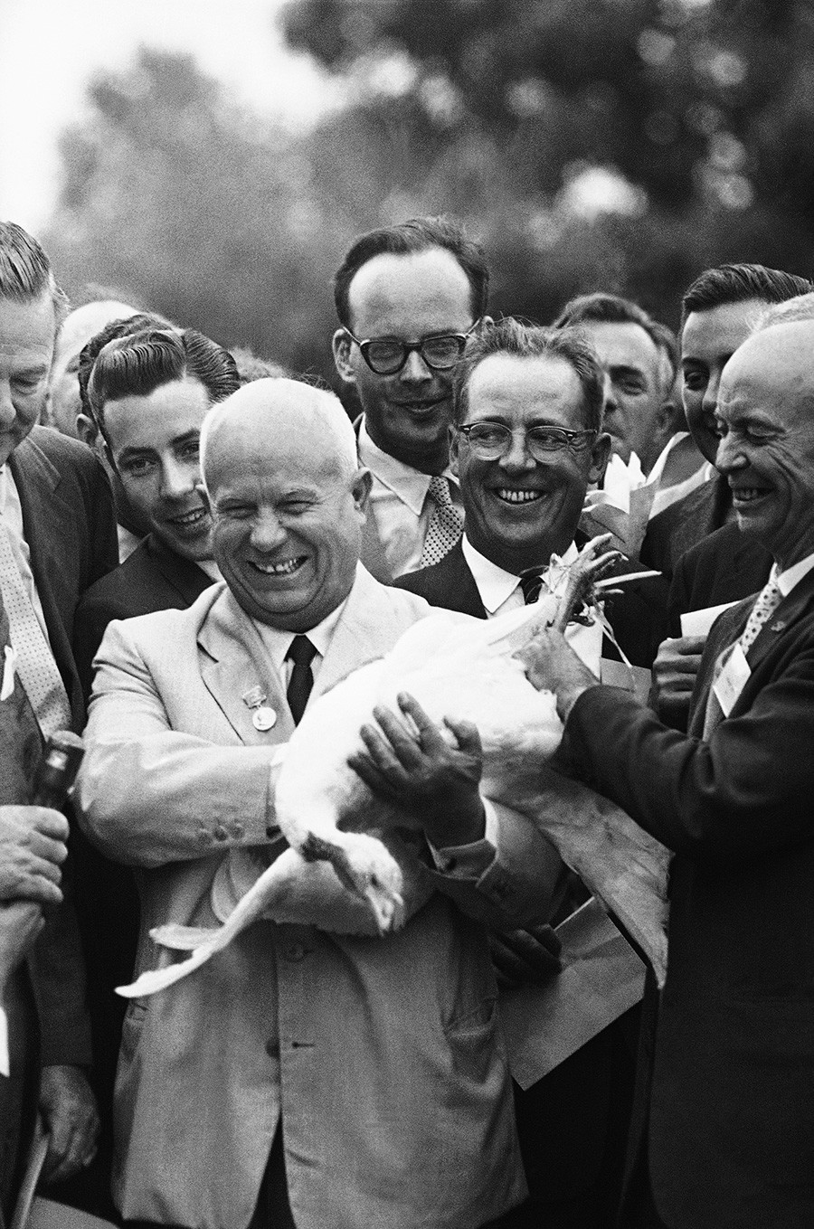 Pemimpin Soviet Nikita Khrushchev tersenyum ketika ia memegang seekor kalkun putih besar pada 16 September 1959 di Beltsville, Maryland, AS.