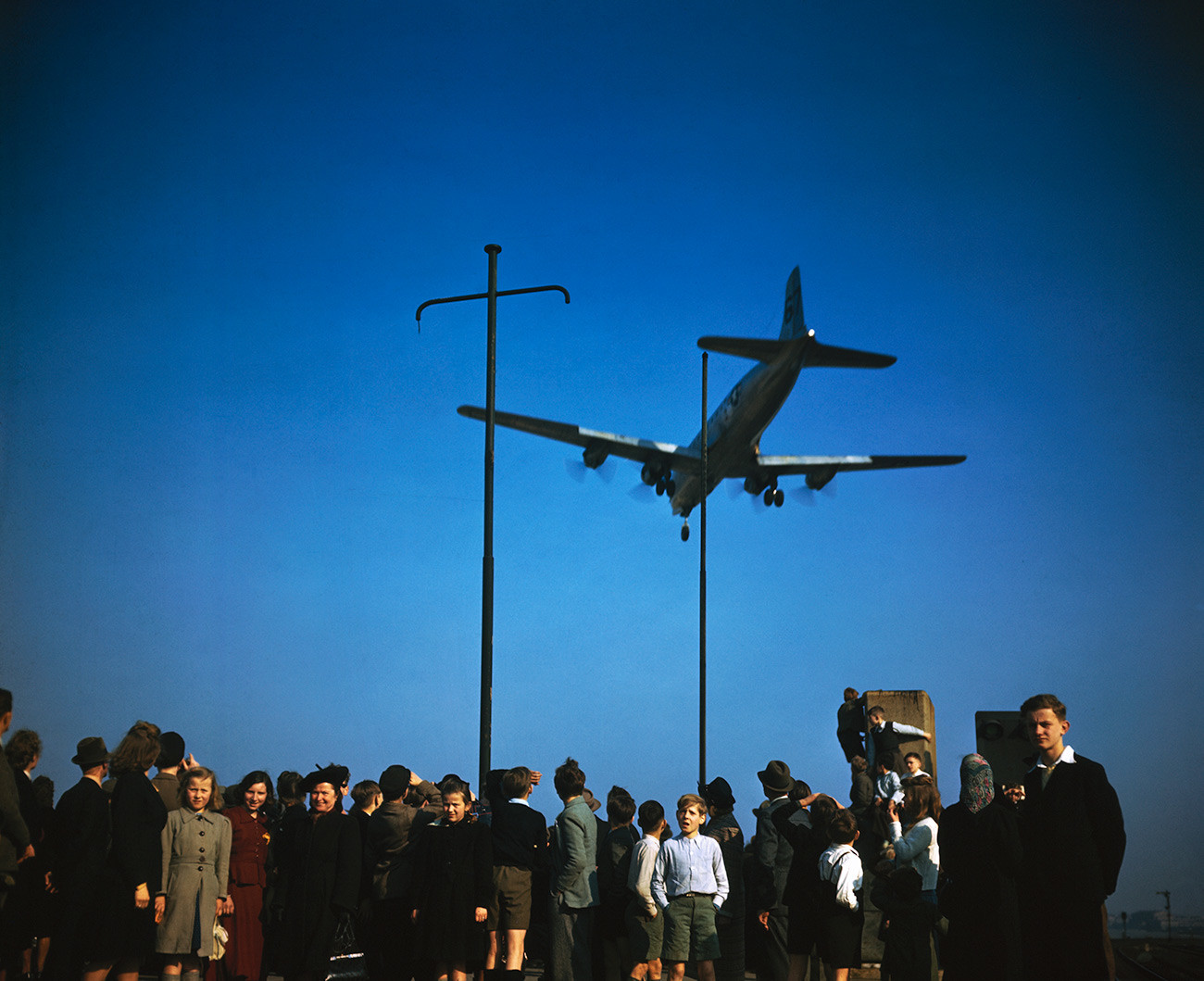 Berliner beobachten die Landung von Flugzeugen der Luftbrücke.
