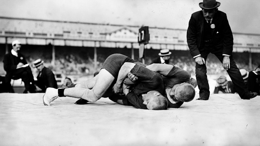 A referee watches the wrestling final at the 1908 London Olympics.