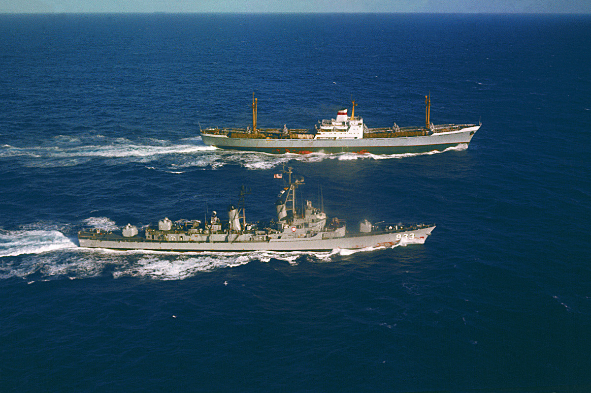 The USS Barry (left) steams alongside the Soviet freighter Ansov, outbound from Cuba, for an inspection of her cargo early today.