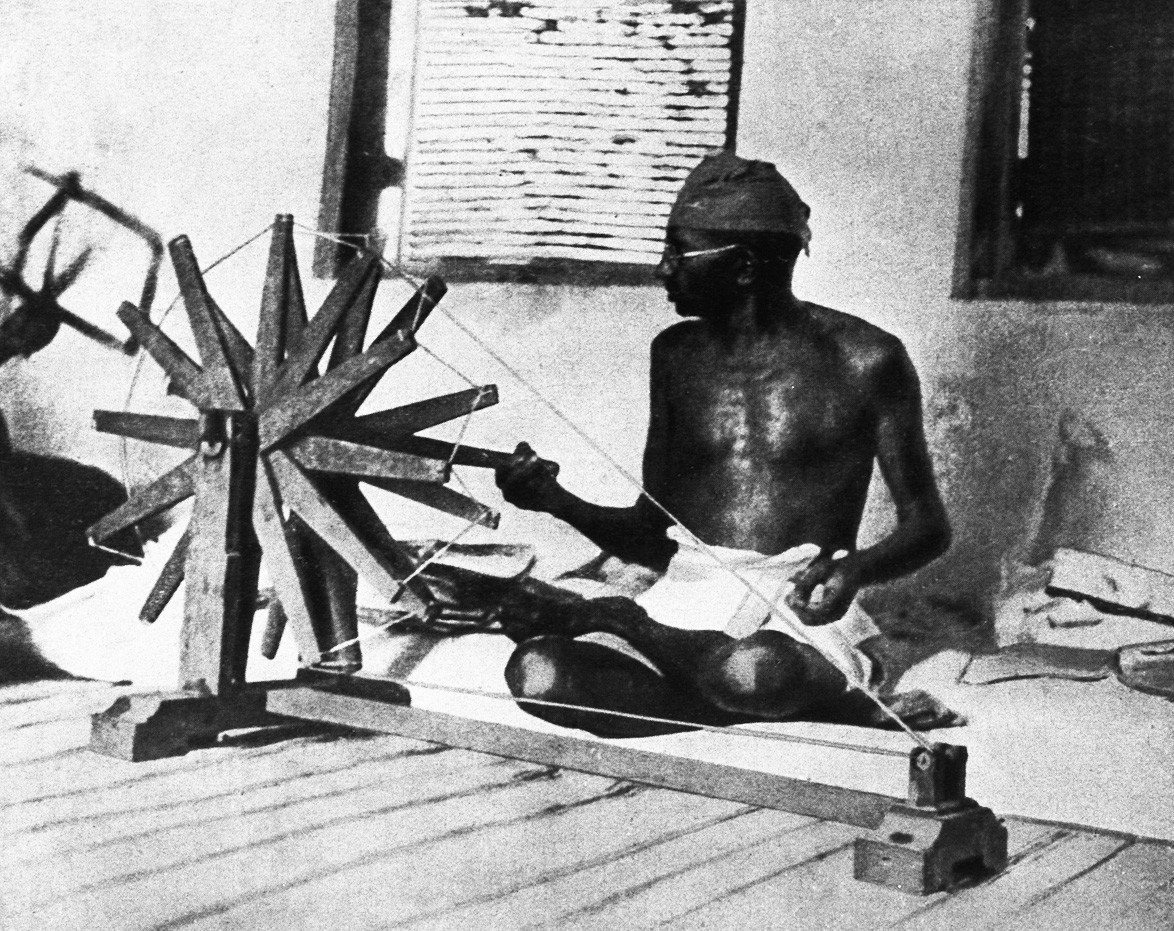 Mahatma Gandhi spinning a cotton-winder. India, 1910.