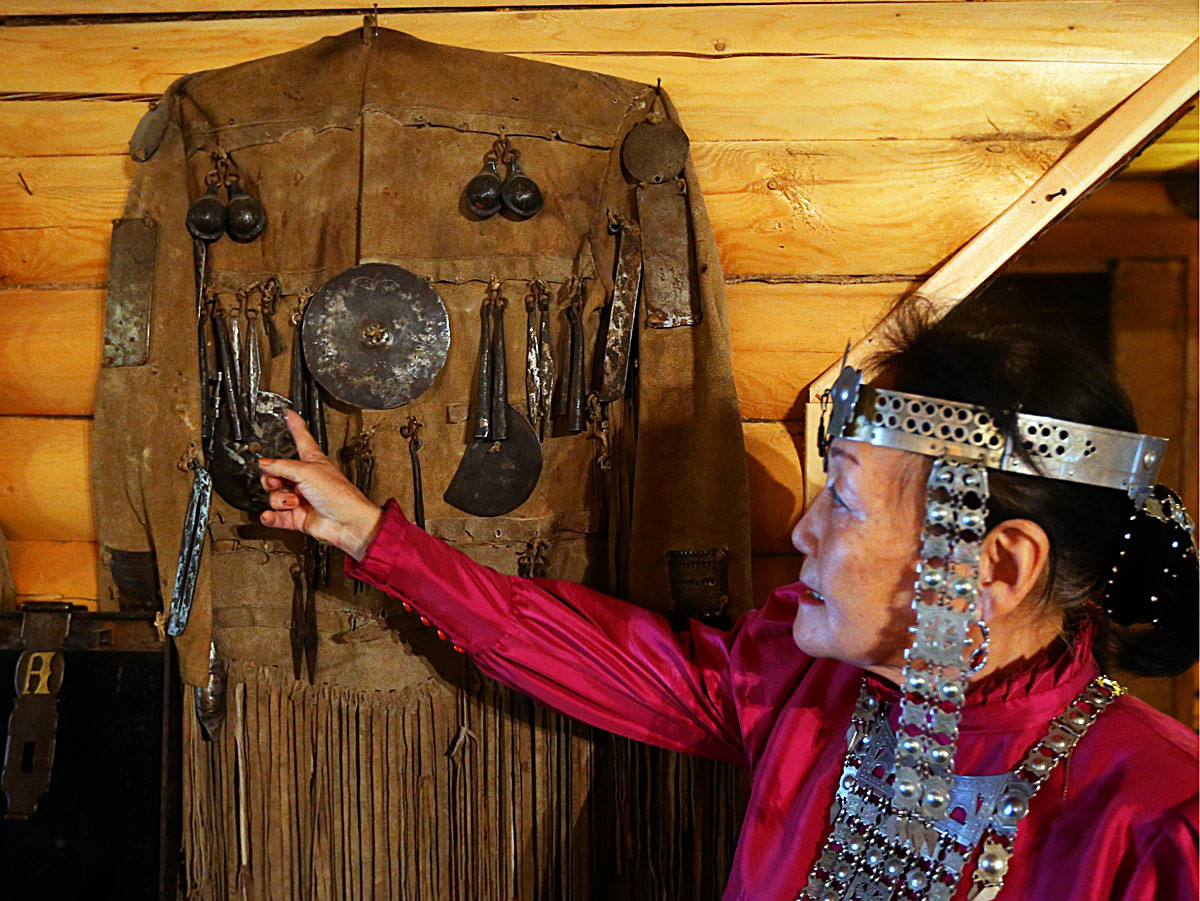 Valentina Atlasova, vestita con gli abiti tradizionali del luogo, mostra un costume da sciamano