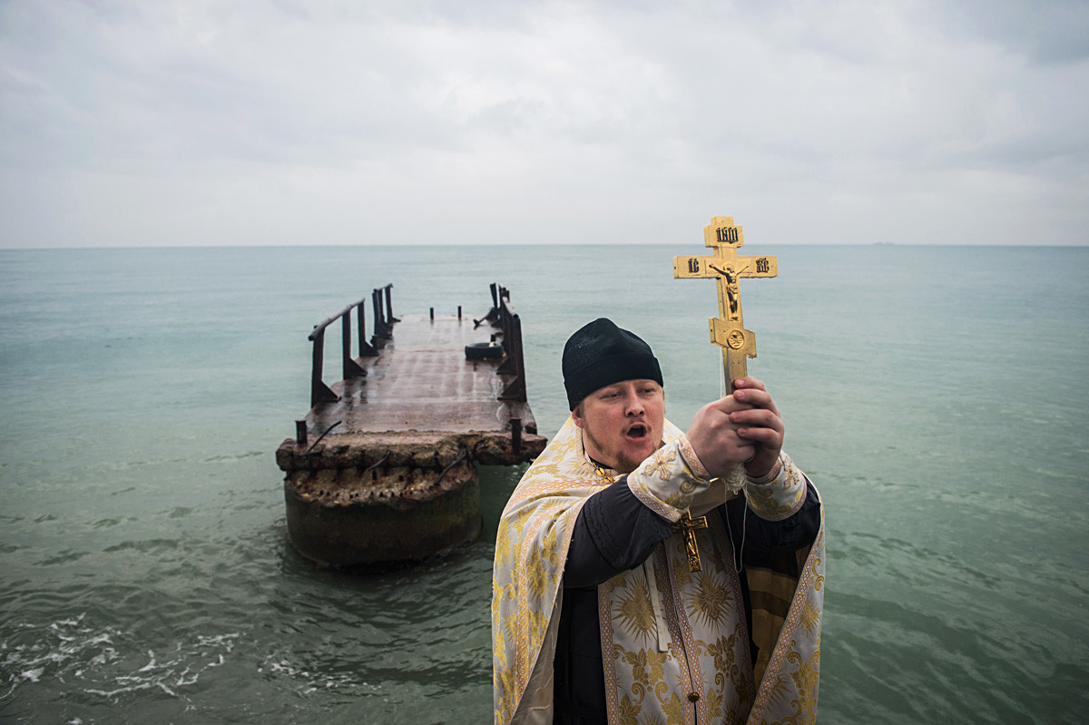 Seorang pendeta memimpin upacara pemberkatan air di Laut Hitam, Distrik Khotinsky, Sochi.
