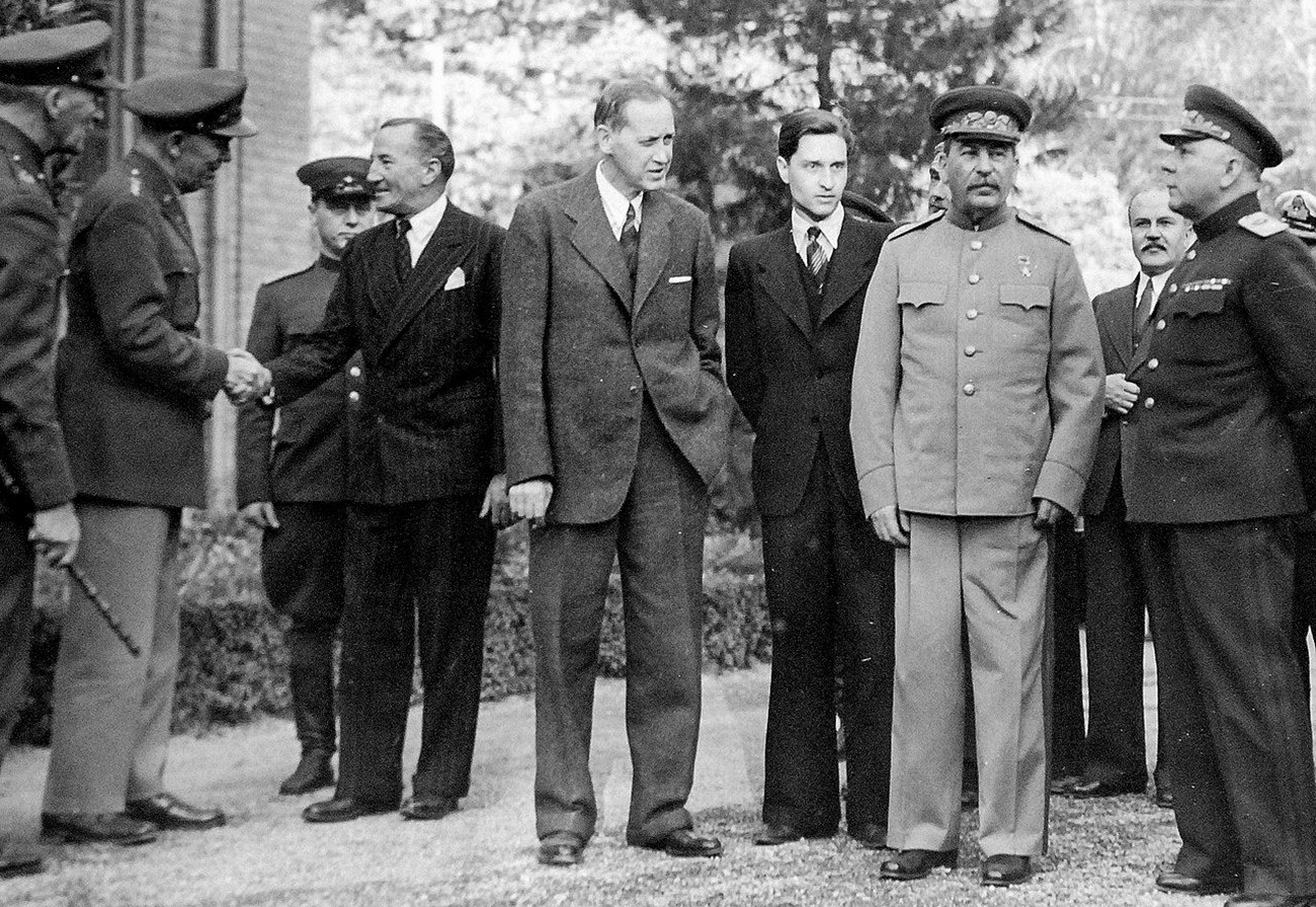 テヘラン会談、1943年11月28日ー12月3日、ロシア大使館の外に立っている（左から）正体不明の英国兵；ジョージ・マーシャルはアルチバルド・ケール英国のソ連大使と握手する；スターリンの通訳者；ハリー・ホプキンス；ヨシフ・スターリン；ソ連の外務大臣ヴャチェスラフ・モロトフ；クリメント・ヴォロシーロフ元帥