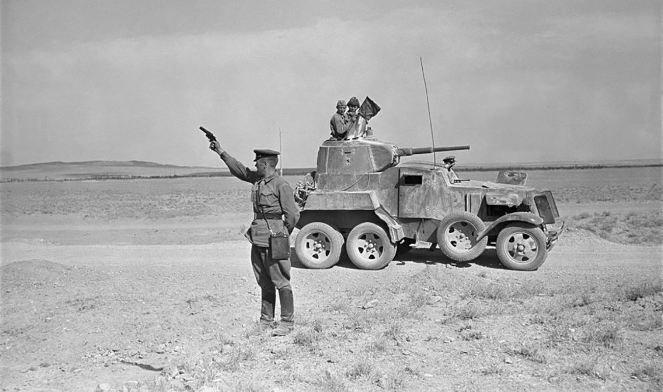 Oficial militar soviético ergue pistola sinalizadora no deserto iraniano