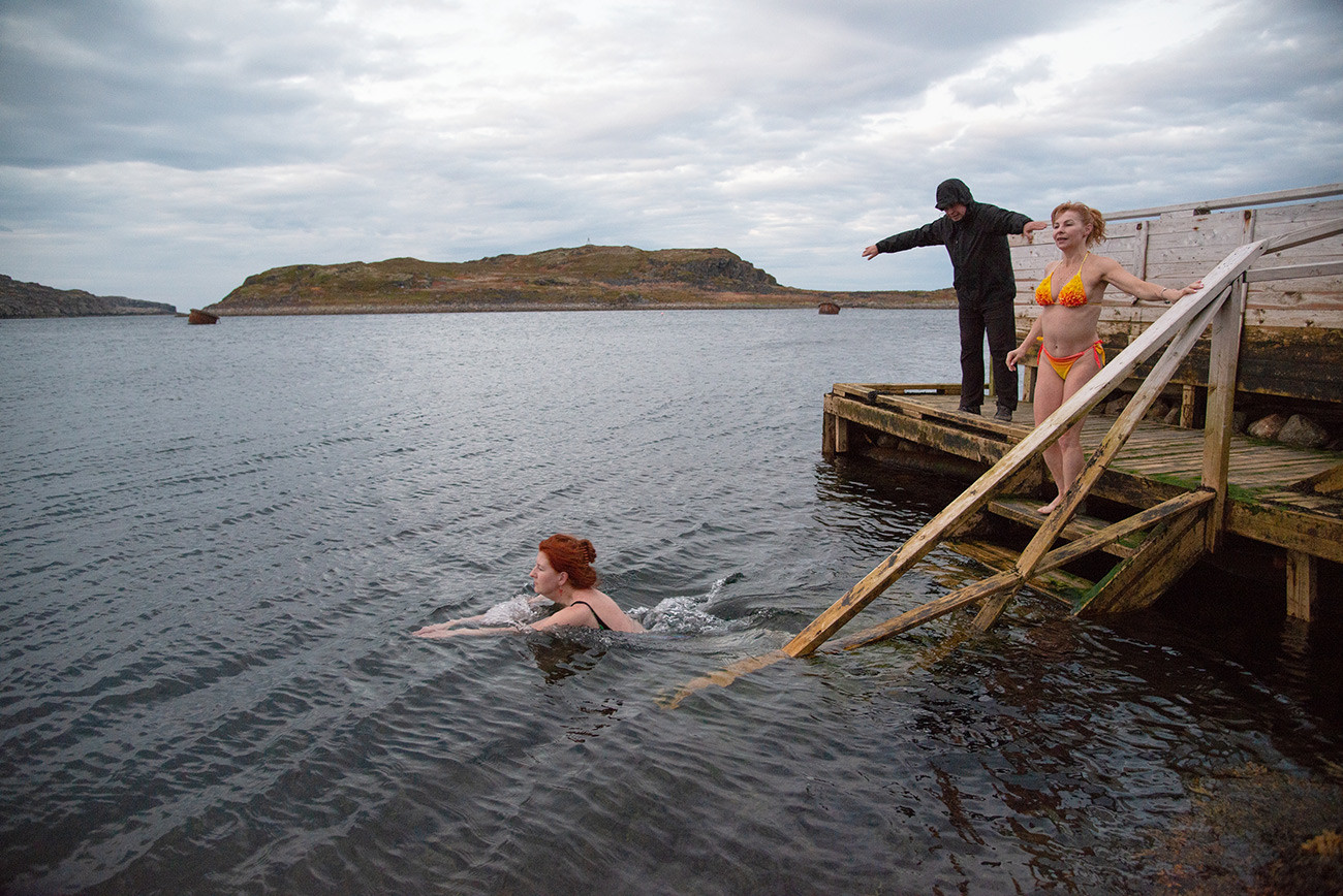 Elena Glazounova, une touriste moscovite, et la locale Lioudmila Sobolevskaïa, se baignent dans la mer de Barents après le bania (sauna russe). La température de l'eau est d'environ -5°. Région de Mourmansk, village de Dalnyé Zelentsy


