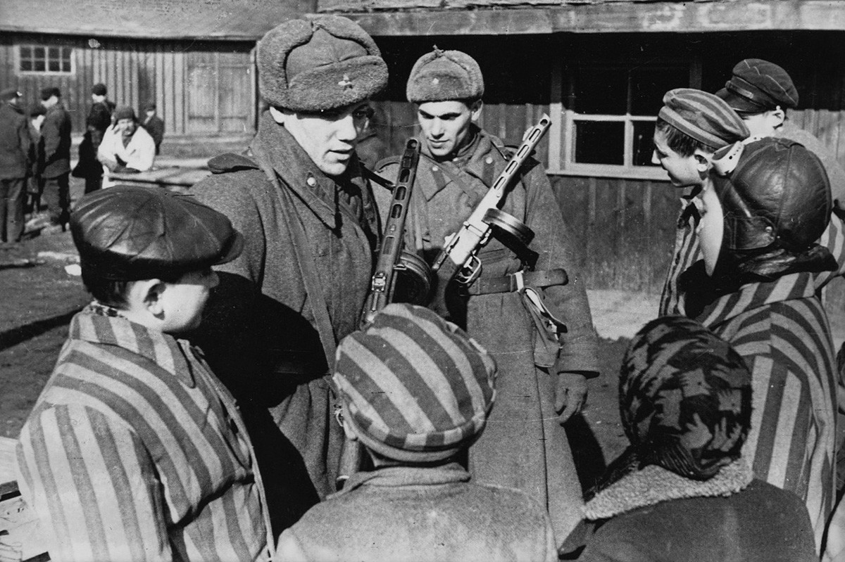 Soldados do Exército soviético conversando com as crianças recém-libertadas do campo de concentração de Auschwitz
