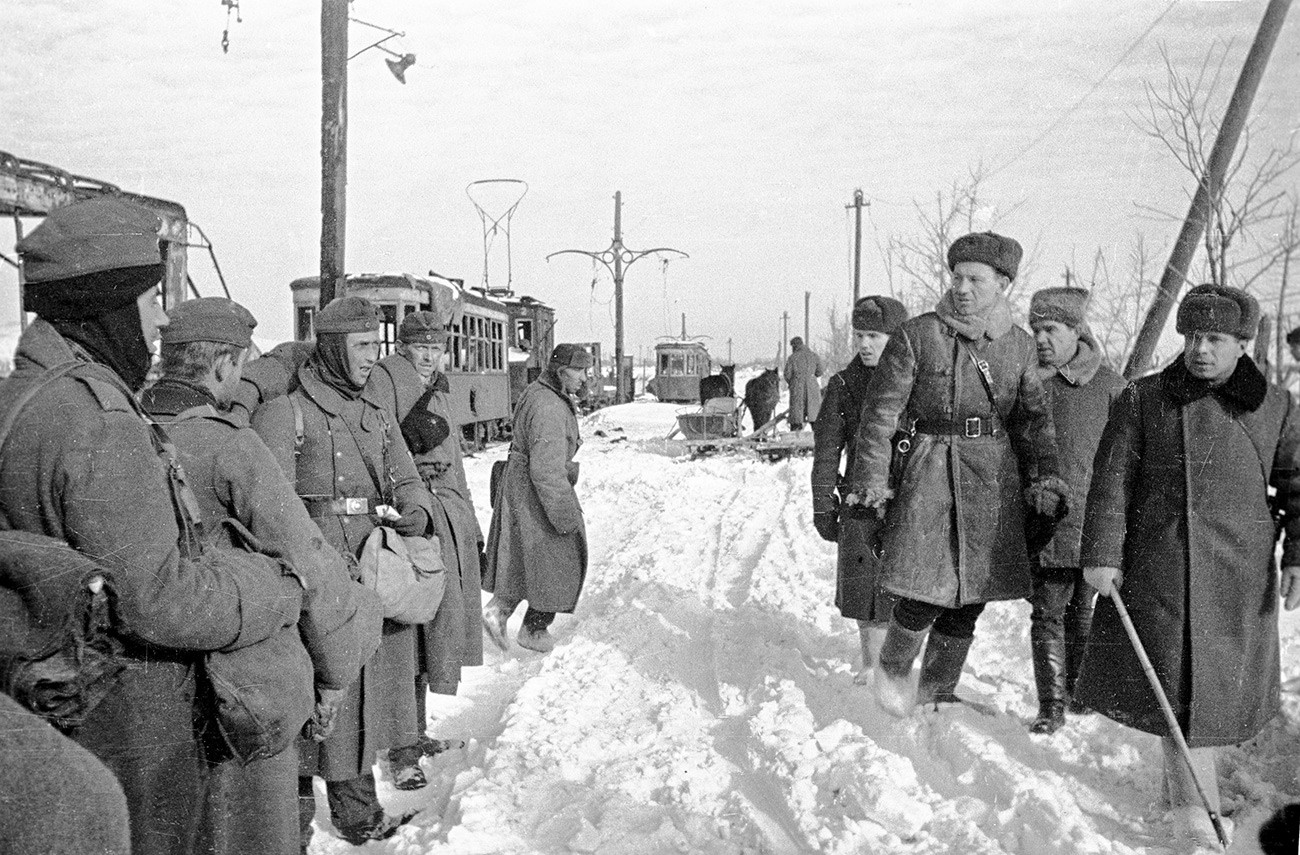 Rencontre. Des officiers soviétiques passent devant des prisonniers allemands. Deuxième à droite : le lieutenant-général Vassili Tchouïkov. Stalingrad, janvier 1943.
