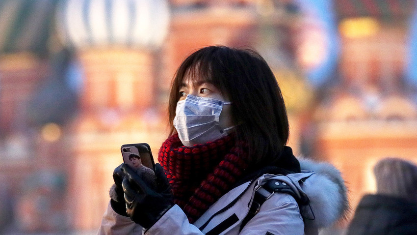 Seorang turis mengenakan masker di Lapangan Merah, Moskow, Rusia, Rabu (29/1).