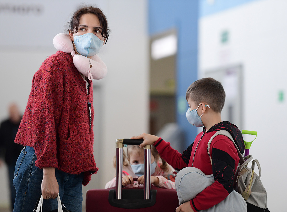 Владивисток, Русија, јануари 31, 2020 - Жена со деца во медицински маски пристигнаа од кинескиот град Сања на меѓународниот аеродром во Владивосток.