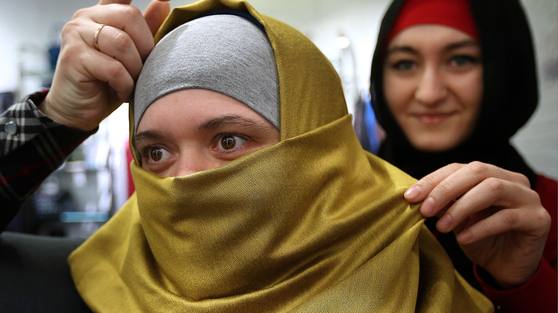 A woman chooses a hijab in a Moscow shopping center.