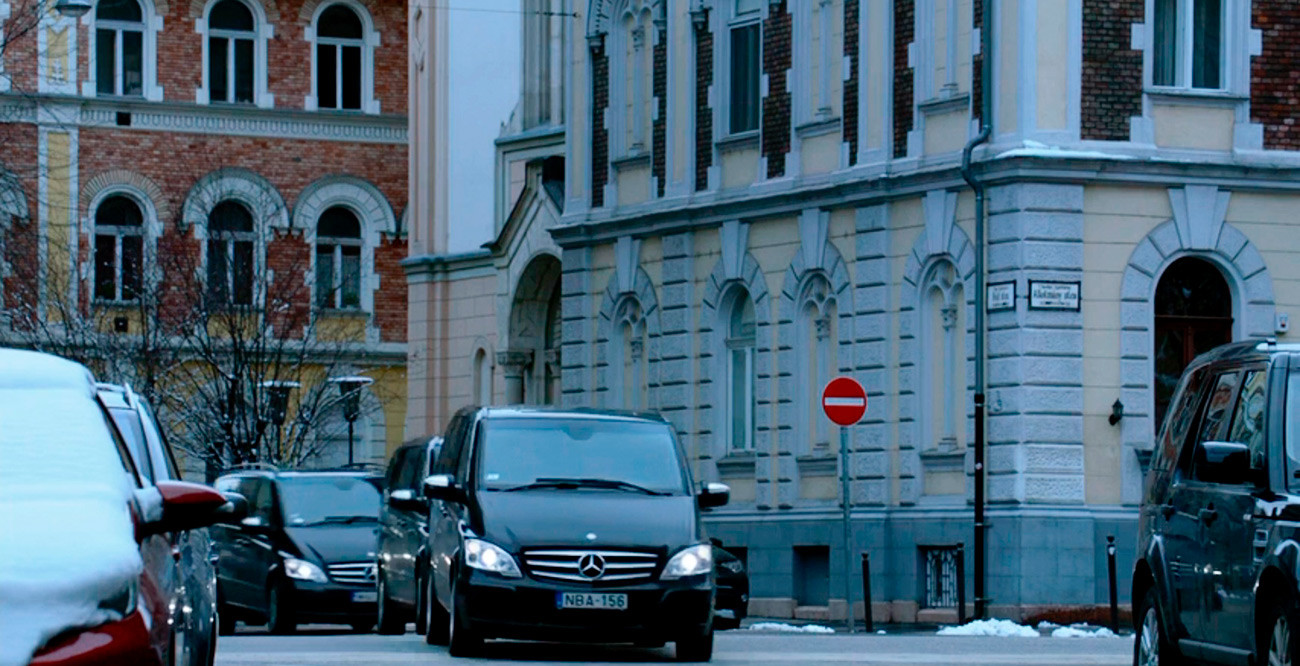This is a Hungarian license plate, and Budapest street signs are visible on the corner of the building