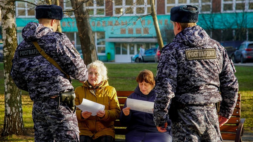 Rosguardia soldiers speak to two pensioners in Moscow.