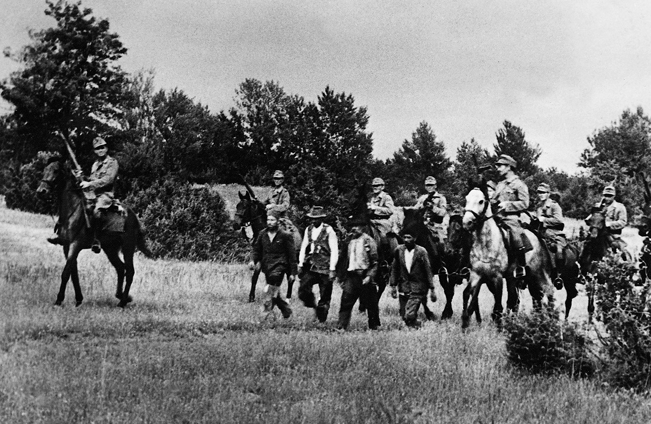  Des cosaques au service d'une unité de la police SS allemande ont chassé des suspects d'une forêt tout en recherchant des partisans.