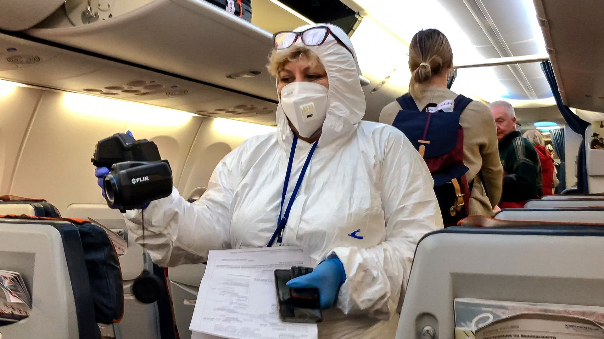 Seorang petuags medis memeriksa penumpang yang tiba dari Italia di dalam pesawat di Bandara Sheremetyevo, Moskow, 8 Maret 2020.